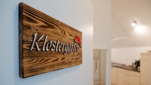 Une pancarte en bois portant l’inscription « Klostergarten » est fixée à un mur.