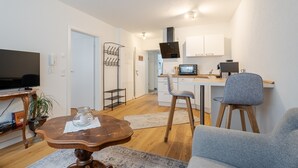 Un espacio habitable compacto con televisión, comedor, cocina y zona de estar.