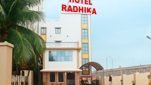 A modern hotel building with a sign reading "HOTEL RADHIKA". - Hotel Radhika (Somnath)