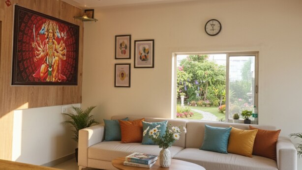 A living room with a sofa, coffee table, and a painting on the wall. - Hotel Radhika (Somnath)