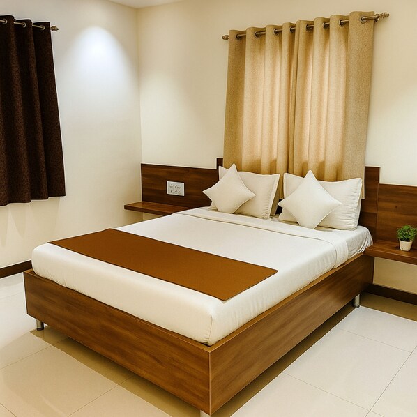 A neatly made bed with a wooden headboard, a bedside table with a lamp, and a window with curtains. - Hotel Radhika (Somnath)