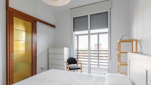 A bedroom with a bed, a chair, a desk, and a window with a view of the city. - Terrazza Masini by Wonderful Italy (Bologna)