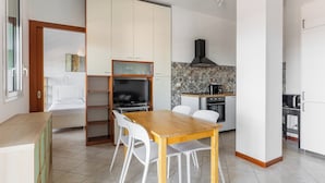 A compact kitchen with a dining area, a built-in TV, and a coffee machine. - Terrazza Masini by Wonderful Italy (Bologna)