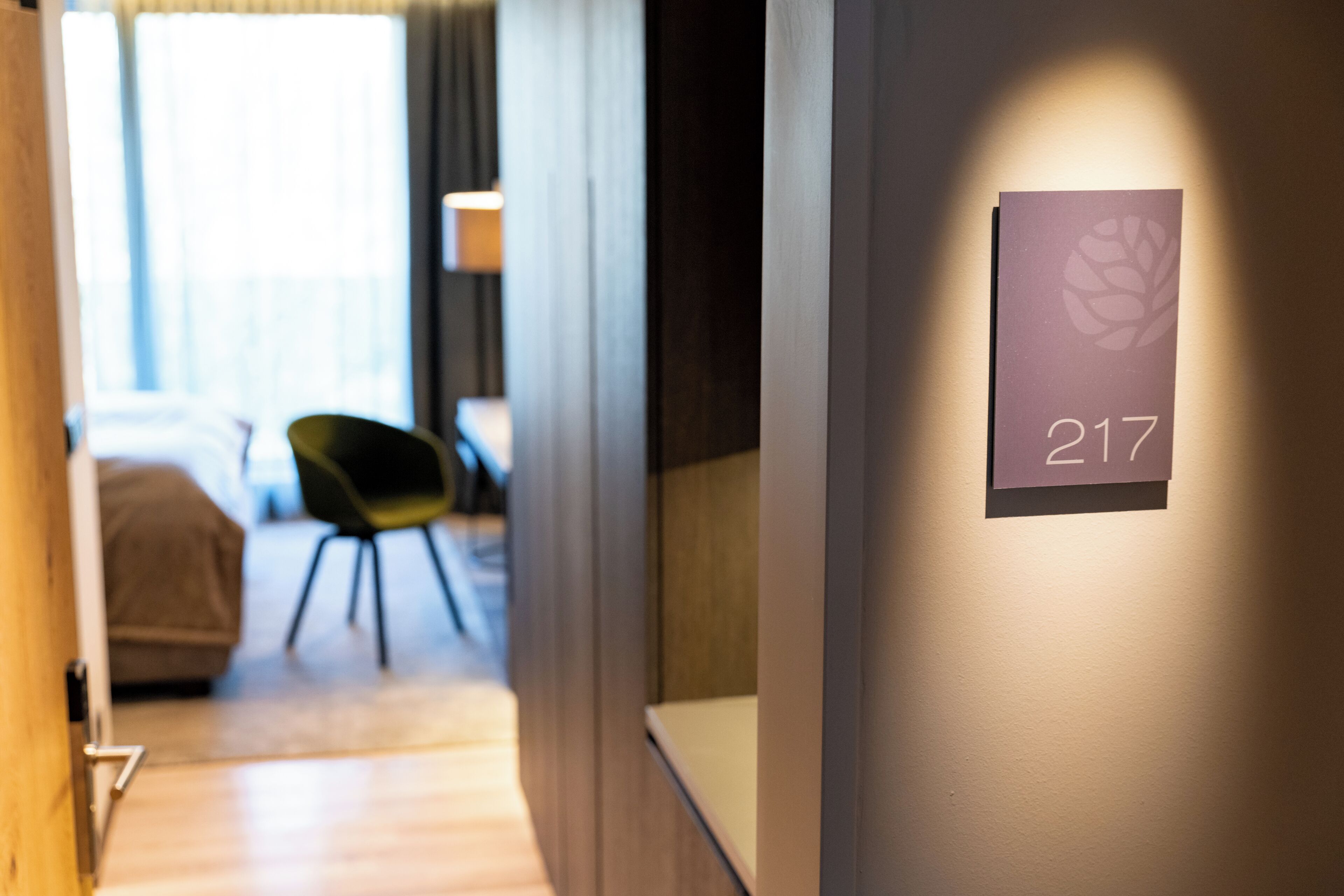 A hotel corridor with a sign indicating room number 217.