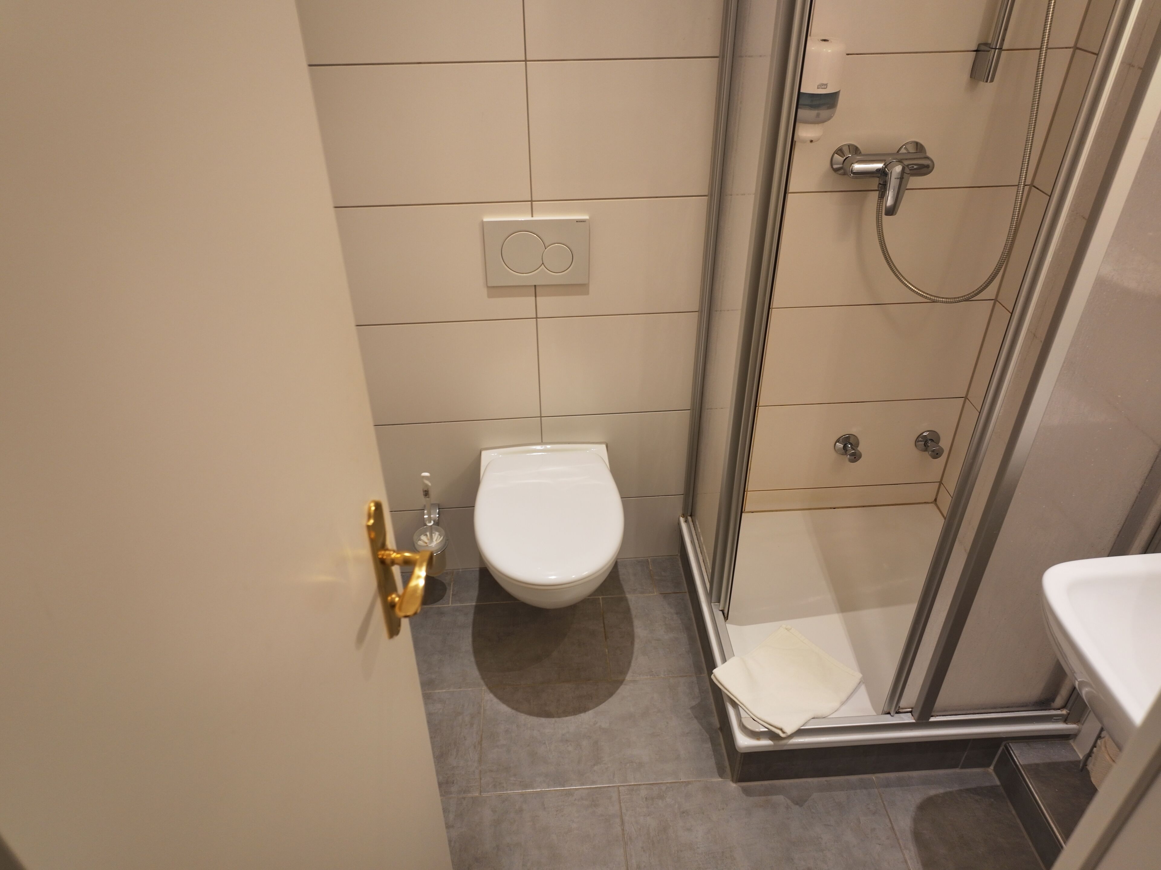 Un bagno piccolo con il water, una doccia e un lavandino.
