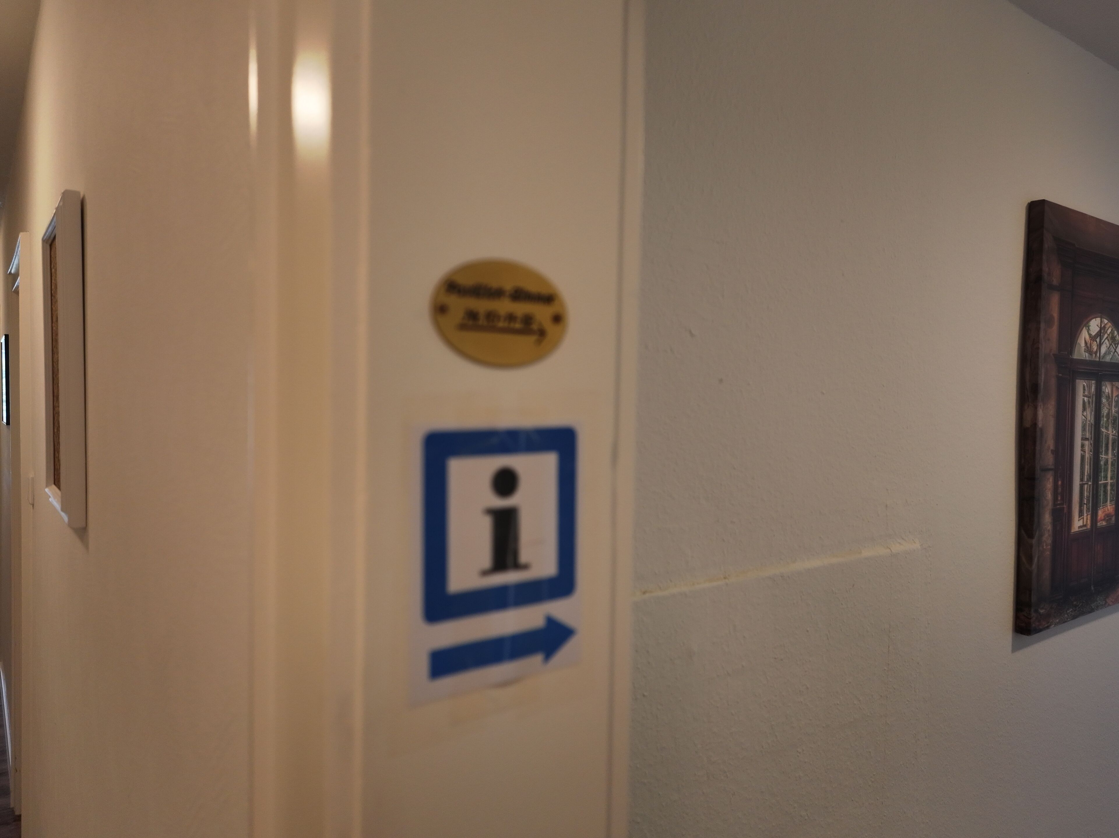 Un mur avec un panneau d’information et une flèche indiquant la direction.