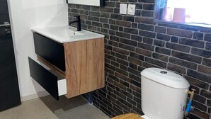 A modern bathroom with a wooden toilet, a white sink, and a black-framed mirror. - Quiet duplex with terrace 3min from Dijon + ring road. Ideal for professionals on the move (Longvic)