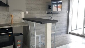 A modern kitchen with a marble countertop, a built-in oven, and a trash bin. - Quiet duplex with terrace 3min from Dijon + ring road. Ideal for professionals on the move (Longvic)