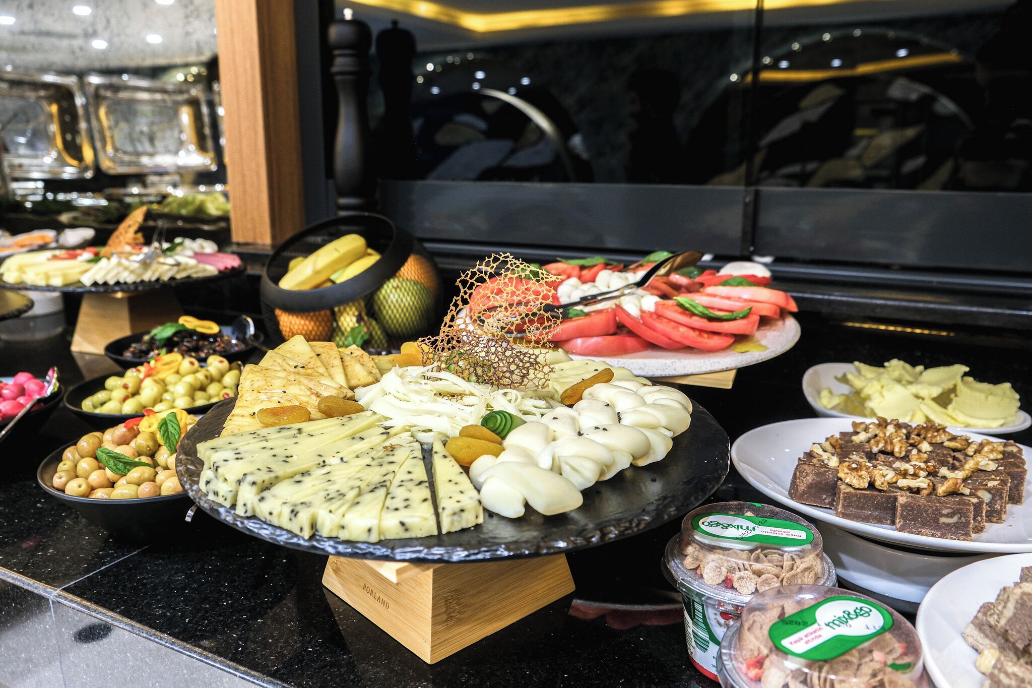 A buffet with various food items including cheese, fruits, and nuts.