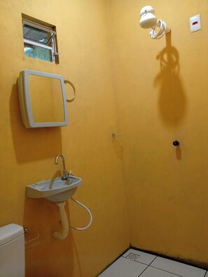 Chuveiro, toalhas de banho, sabonete, papel higiênico