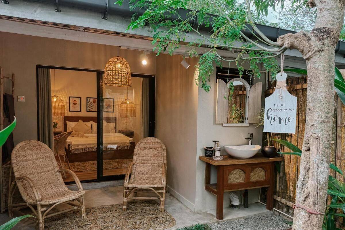 A cozy room with wicker chairs, a large window, and a wooden vanity with a bowl sink.