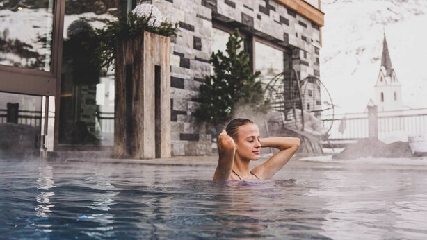 Une personne dans une piscine, avec un bâtiment en arrière-plan.