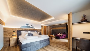 Une chambre moderne avec un grand lit, un bureau et un coin lecture confortable.