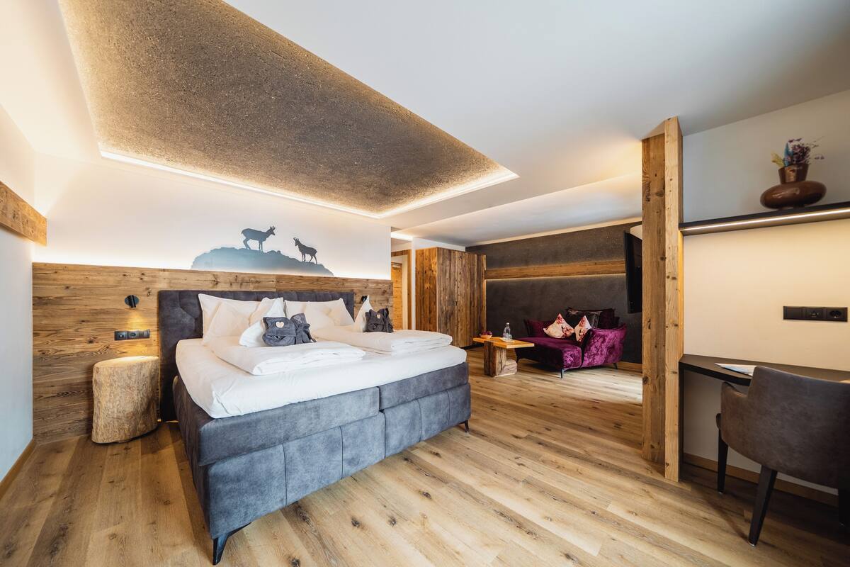 Un dormitorio moderno con una cama grande, un escritorio y una zona de lectura acogedora.