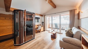 Un intérieur moderne avec un plancher en bois, un canapé, un bureau et une porte-fenêtre coulissante donnant sur un balcon.