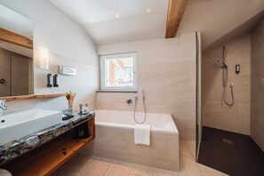 Un bagno moderno con una grande vasca da bagno, una cabina doccia separata e un mobile lavabo con lavandino e specchio.