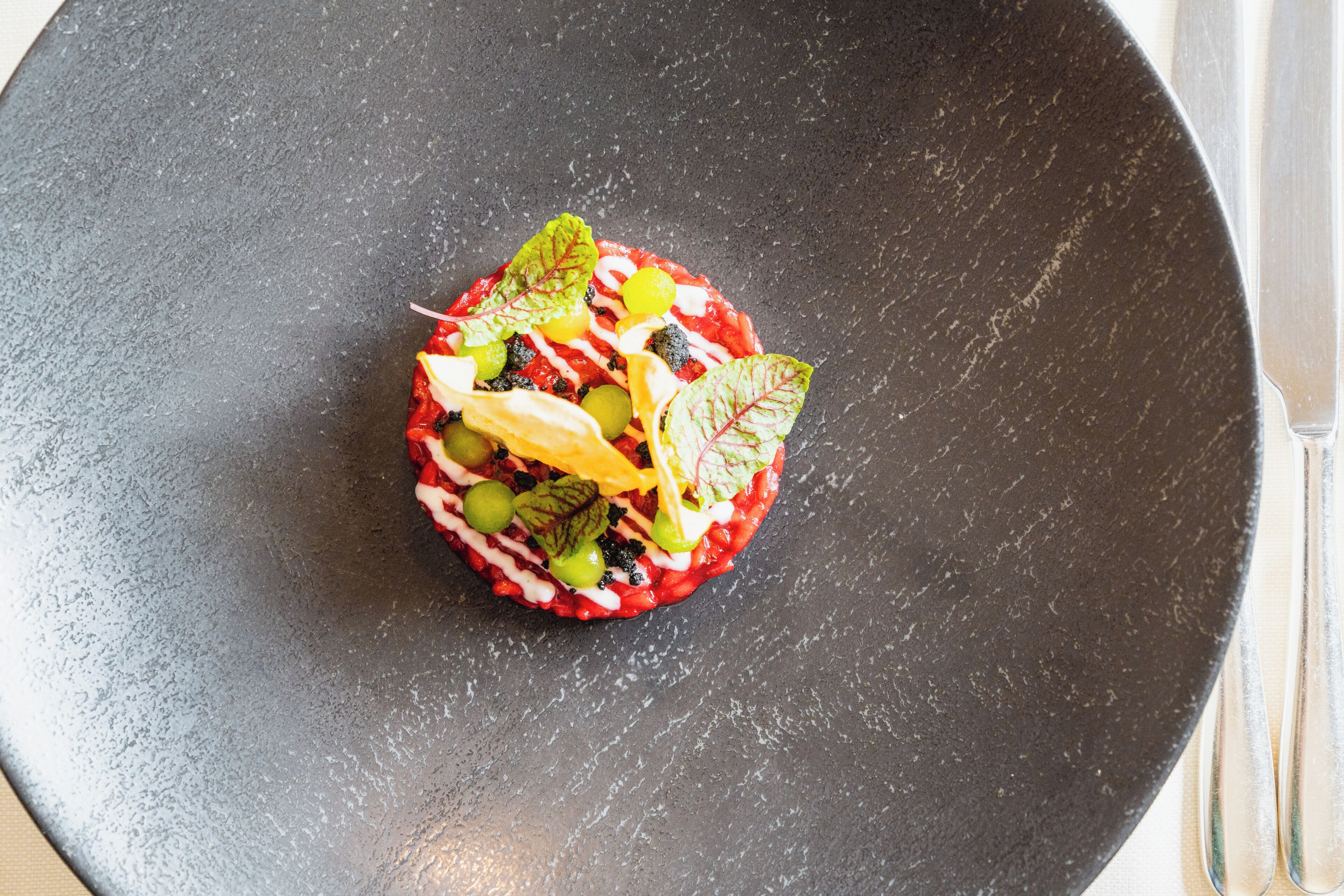 A black plate with a colorful food arrangement.