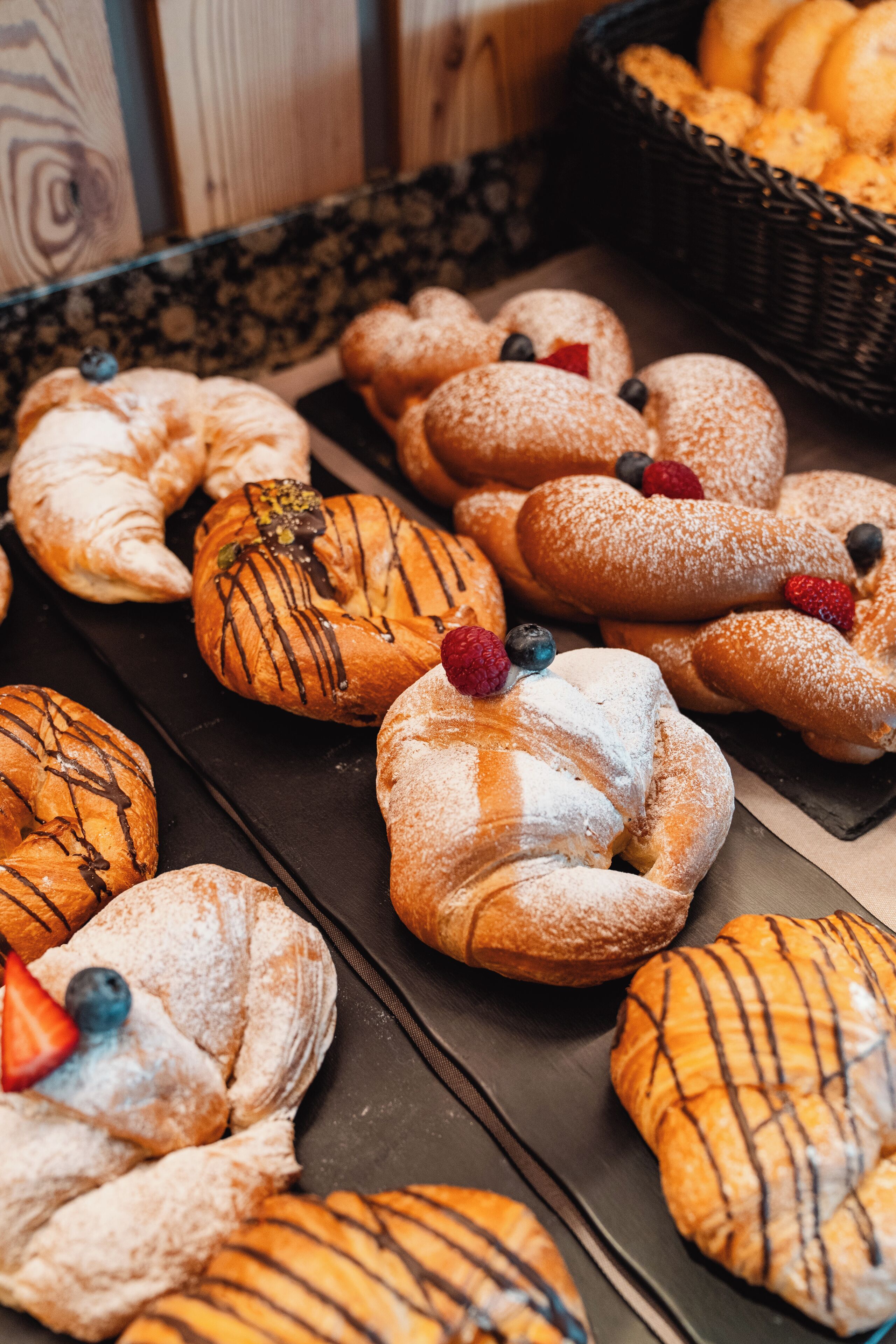A variety of pastries, including croissants and danishes, arranged on a tray.