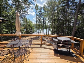Une terrasse en bois avec un barbecue et des sièges d’extérieur.