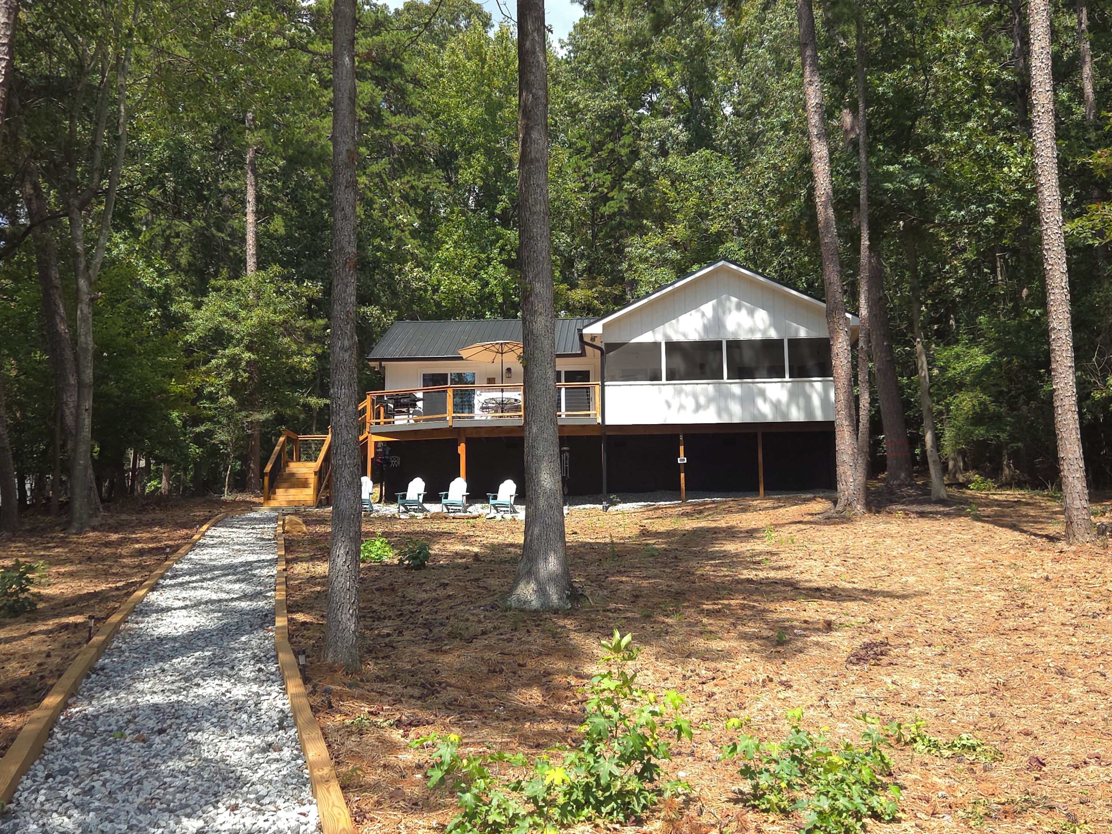 A two-story house with a covered deck and outdoor seating area.