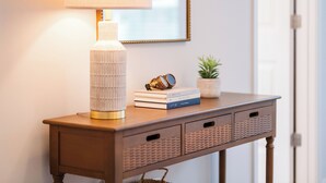 A wooden console table with a lamp, books, and decorative items.