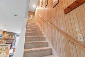Eine Treppe mit Teppichstufen führt zu einer Holzwand mit Handlauf.