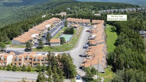 A ski resort with a row of cabins, a parking lot, and a ski trail named "Ski Out Trail 'Shamrock' (Green)".