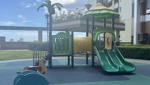 Une aire de jeux avec un toboggan, des structures d’escalade et un espace de jeu en forme de tortue.