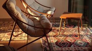 Una habitación con dos sillones de cuero, una mesa de centro de madera y una alfombra estampada.