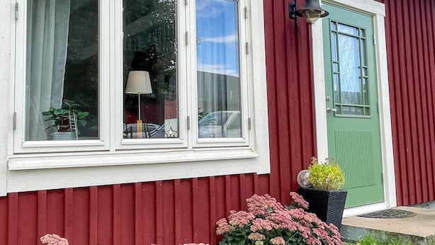 A red building with white-framed windows and a green door. - 4 Person Holiday Home in Berga (Berga)