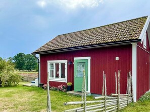 A red building with a green door, white windows, and a tiled roof. - 4 Person Holiday Home in Berga (Berga)