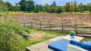 A wooden deck with outdoor furniture, a fenced area, and a field in the background. - 4 Person Holiday Home in Berga (Berga)
