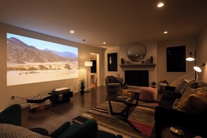 Un salon doté d’un grand écran de télévision, d’une cheminée et d’un coin salon confortable.