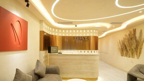 A reception area with a curved counter, a Marshall speaker, and a reception desk. - J Village Hotel - Triệu Việt Vương (Hanoi)