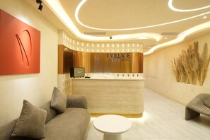 A reception area with a curved counter, a Marshall speaker, and a reception desk. - J Village Hotel - Triệu Việt Vương (Hai Ba Trung)