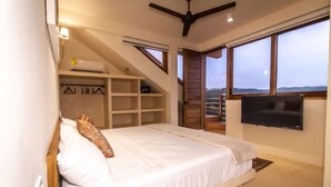 A bedroom with a bed, built-in shelves, a TV, and a balcony with a view. - Ocean Views w/ Rooftop Lounge (Mazunte)