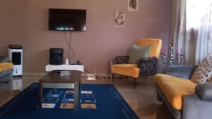 A living room with a sofa, armchair, coffee table, TV, and speaker. - Studio for 2 persons (Ebolowa, Région du Sud)