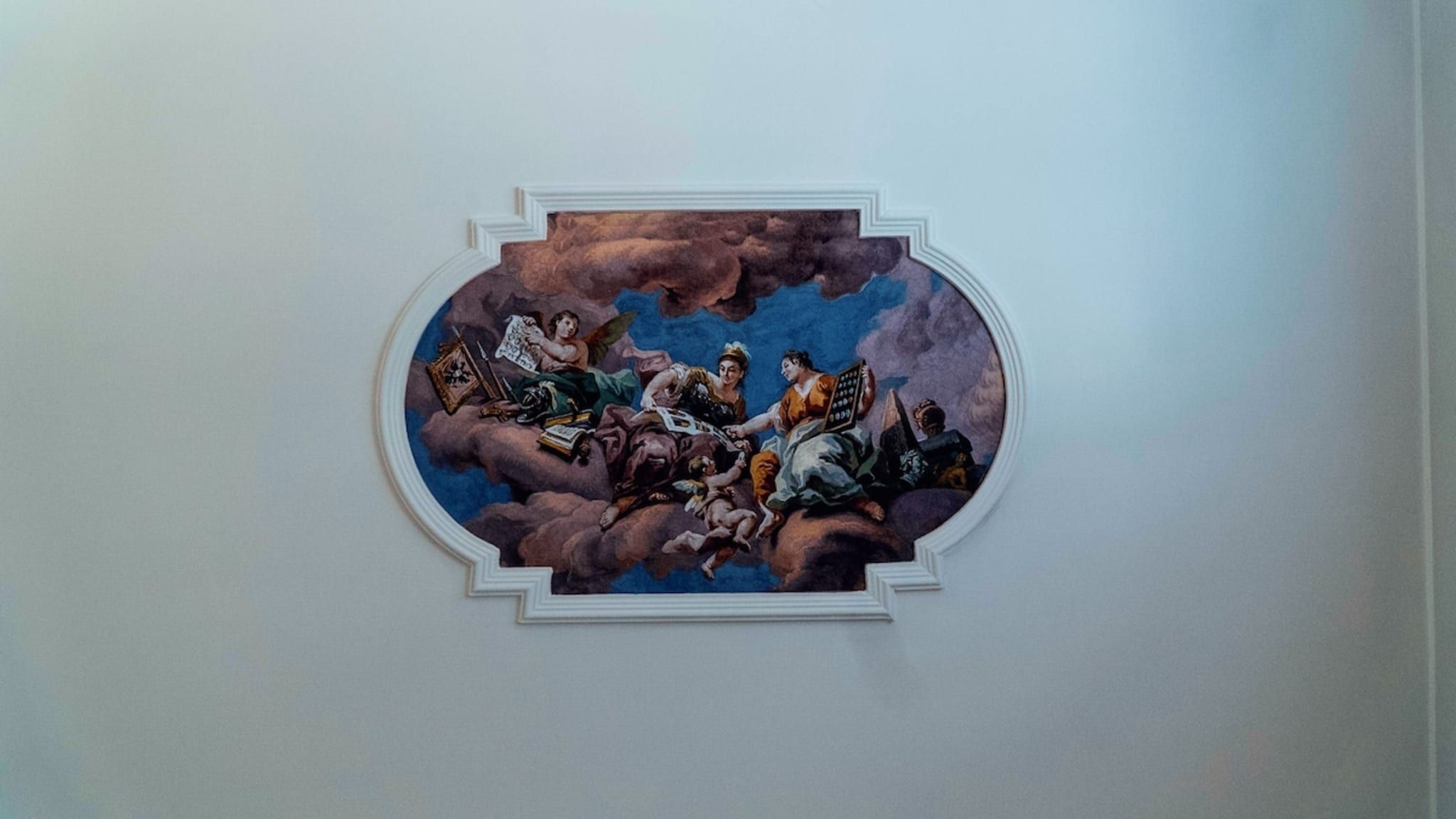 Un fresco en el techo con escena clásica.