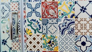 Una pared con diversos diseños de azulejos coloridos, incluyendo motivos florales y geométricos.