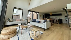 Un salón amplio con sofá, mesa de centro y mesa de comedor.