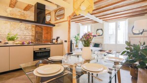 A modern kitchen with a dining area. - Historic Charm Meets Modern Comfort (Barcelona)