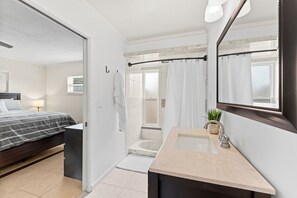 A modern bathroom with a shower, sink, and a large mirror.
