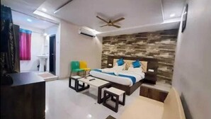 Ein modernes Hotelzimmer mit Bett, Schreibtisch, Stuhl und kleinem Tisch.
