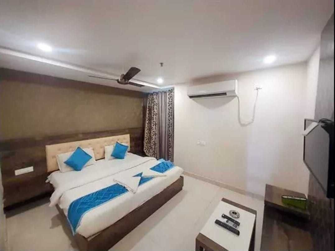 A bedroom with a bed, bedside table, and a TV.
