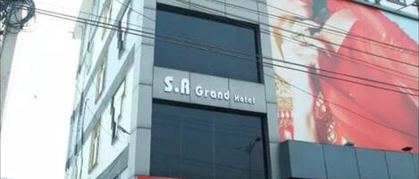 A multi-story building with a prominent 'Grand Hotel' sign on the ground floor.