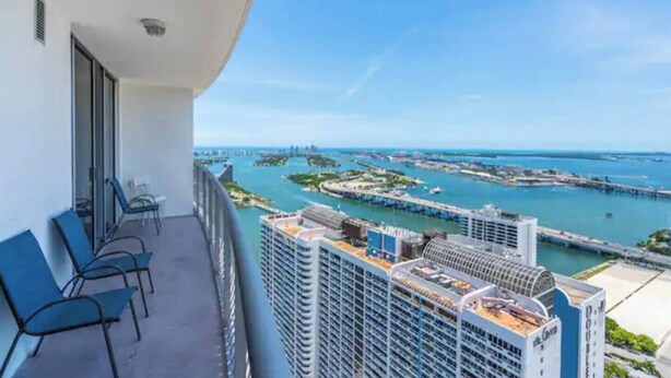 A balcony with a view of a marina and buildings. - Edgewater High-Rise | Stunning Bay Views + Gym (Miami)
