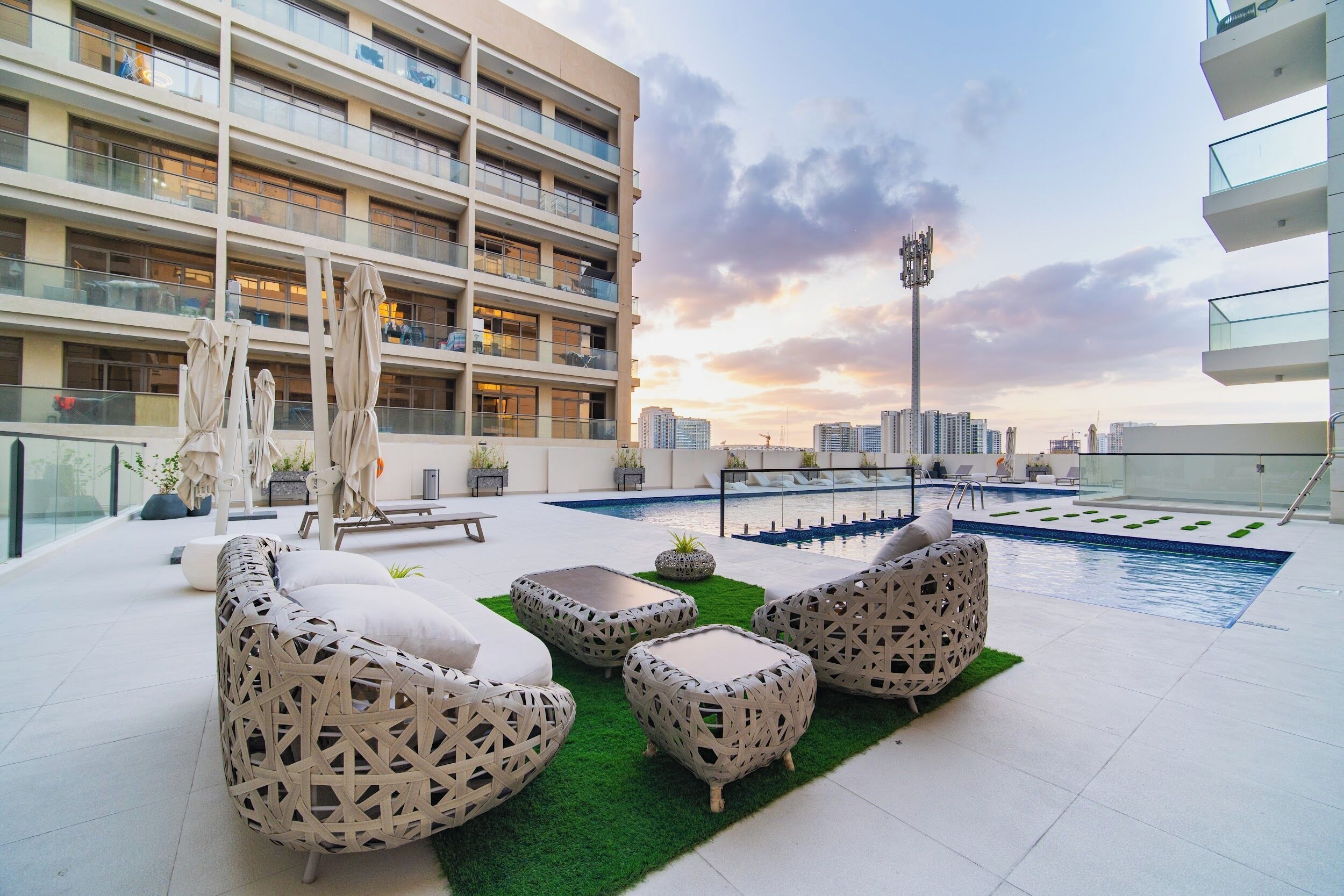 Zona de piscina en la azotea con mobiliario exterior y vistas a la ciudad.