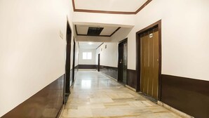 Un pasillo con suelo de baldosas, techo con iluminación empotrada y una puerta marcada con el número 109.