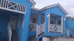 A blue building with white railings and a staircase leading to the entrance. - Cottage at Coverley (Christ Church)