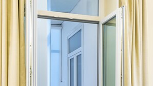 An open sliding door leading to a narrow hallway with a table and chairs. - Modern Spacious Apartment in the Heart of Naples (Naples)